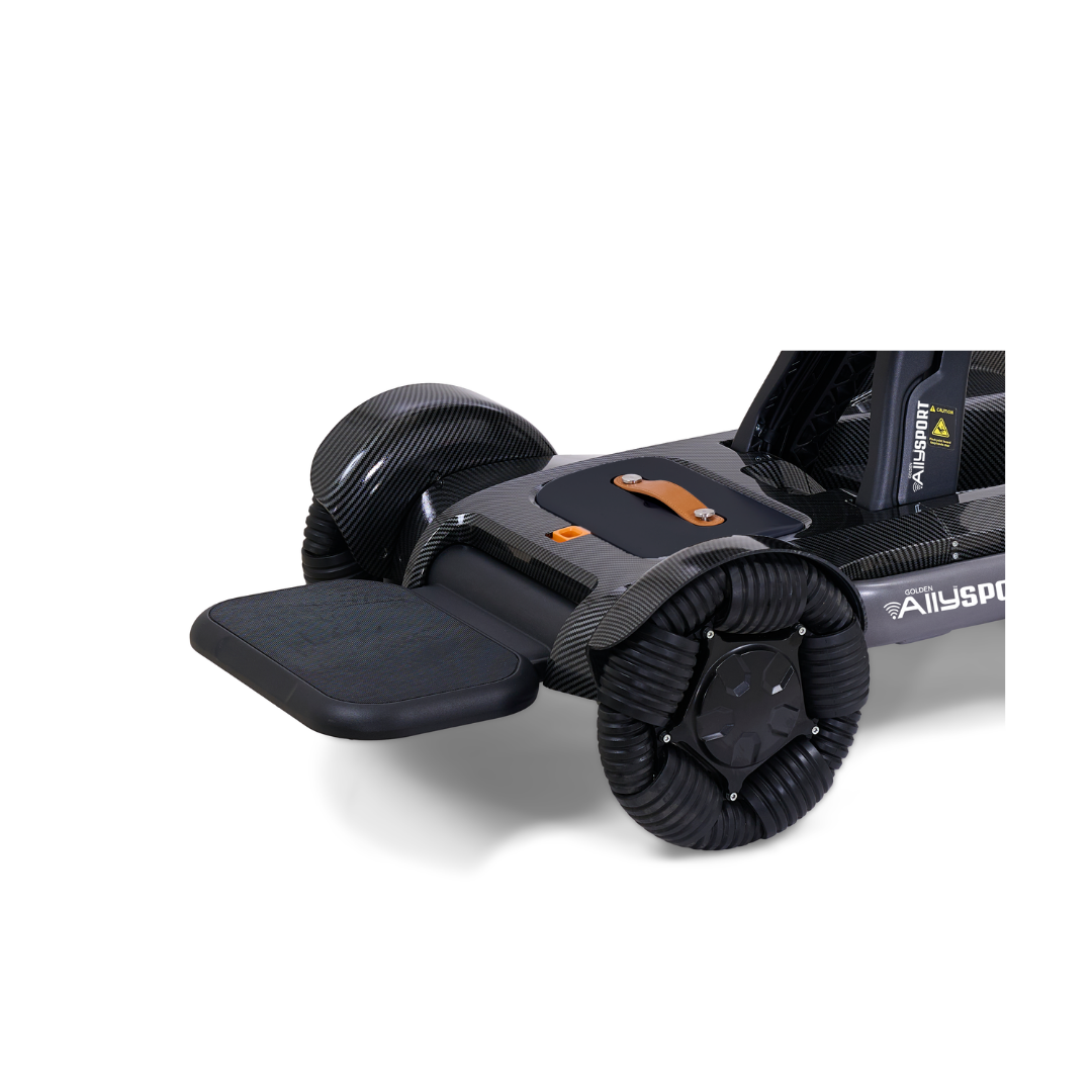 Close-up of a black mobility scooter with a textured footrest, thick ribbed wheels, and carbon fiber accents, featuring the Golden Ally Sport Batteries - 10 AH Lithium-Ion Travel Battery, against a white background.